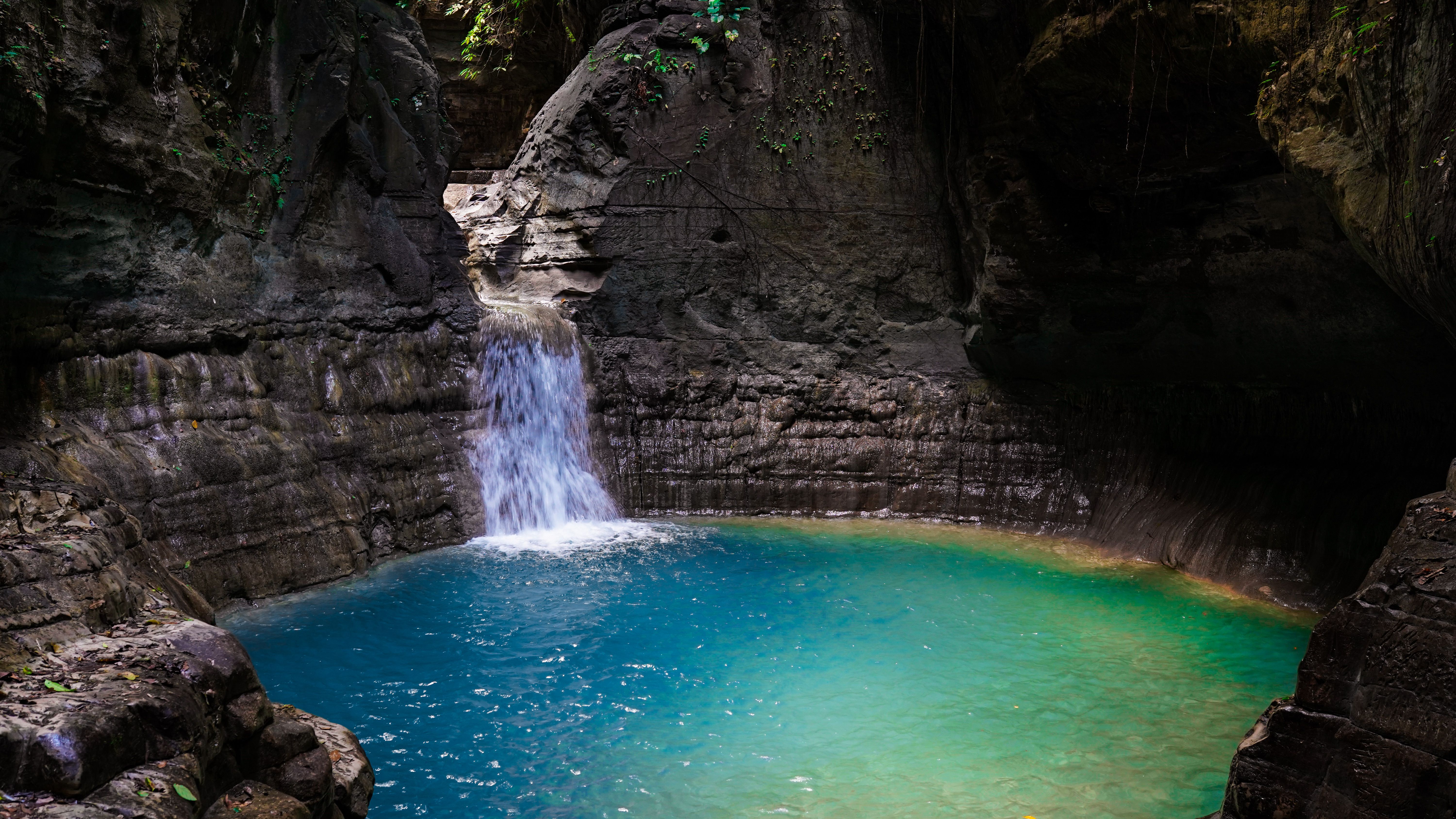 Waterfall cascading through a rocky tropical landscape