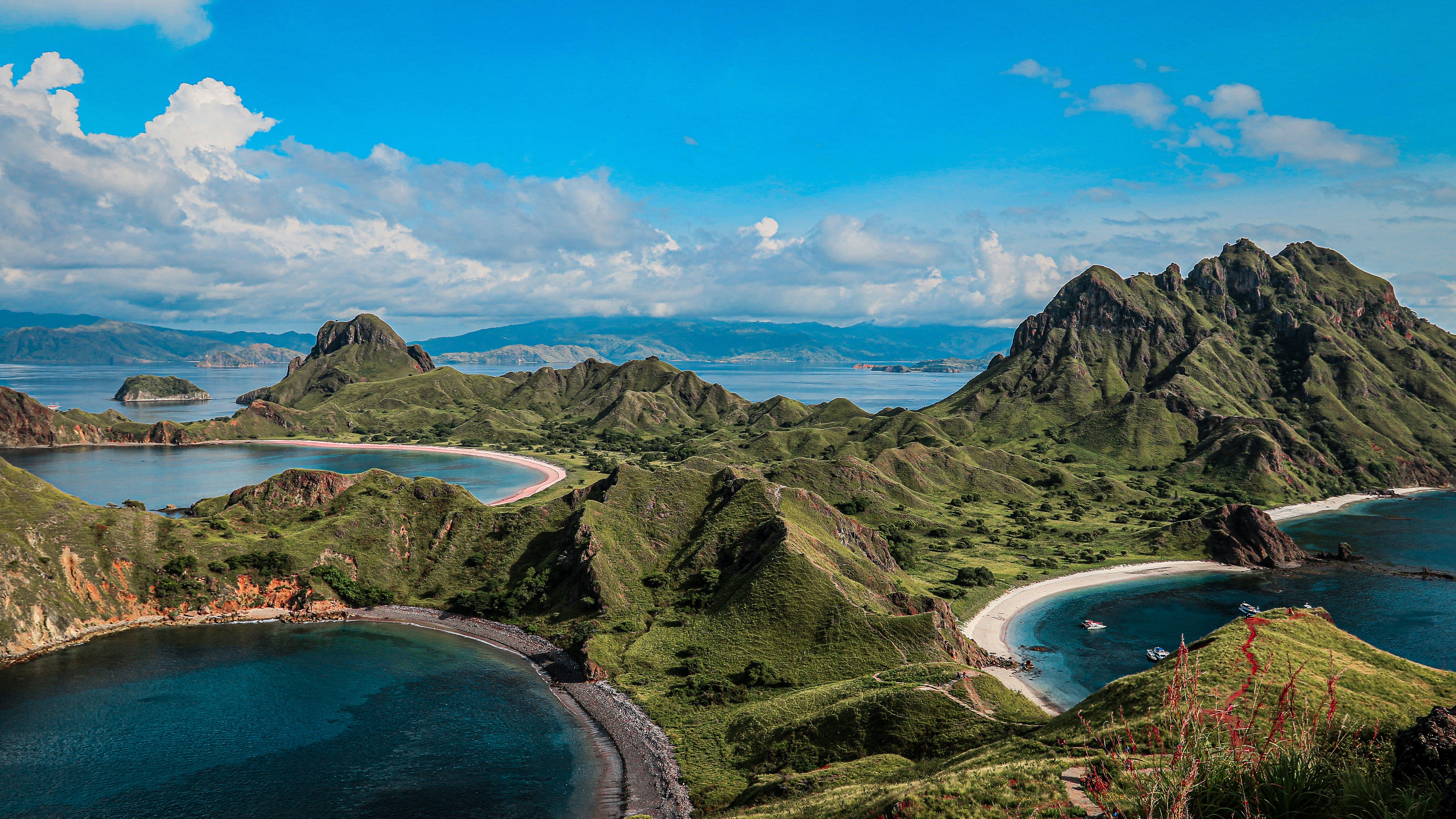 Panoramic aerial view of Padar Island’s green hills and turquoise bays in Komodo National Park
