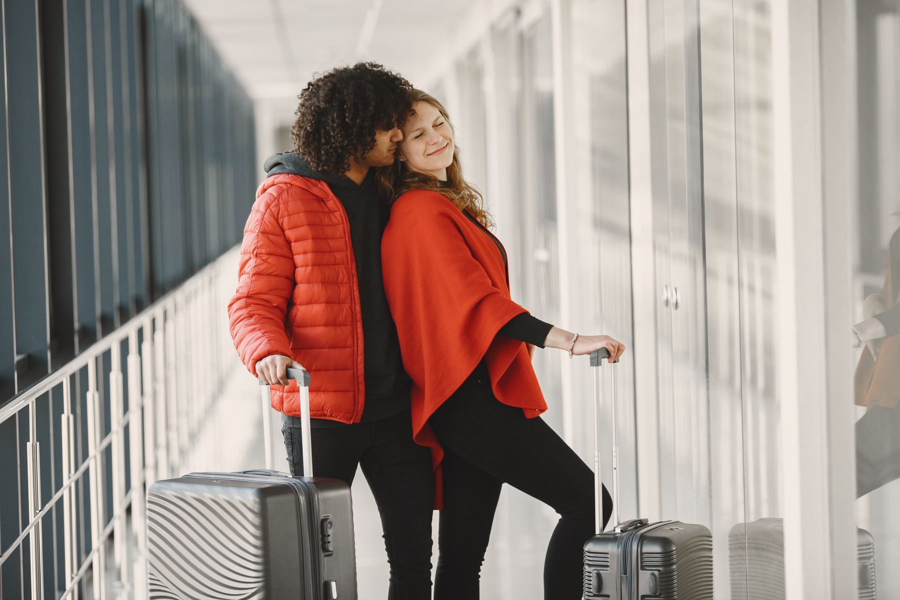 A couple with luggage in an airport corridor