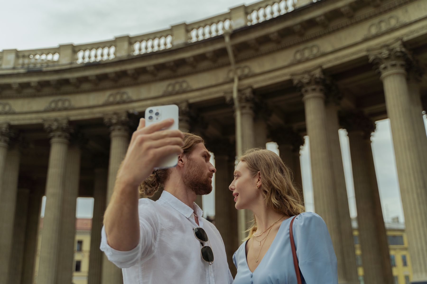 A couple taking a selfie by classical columns