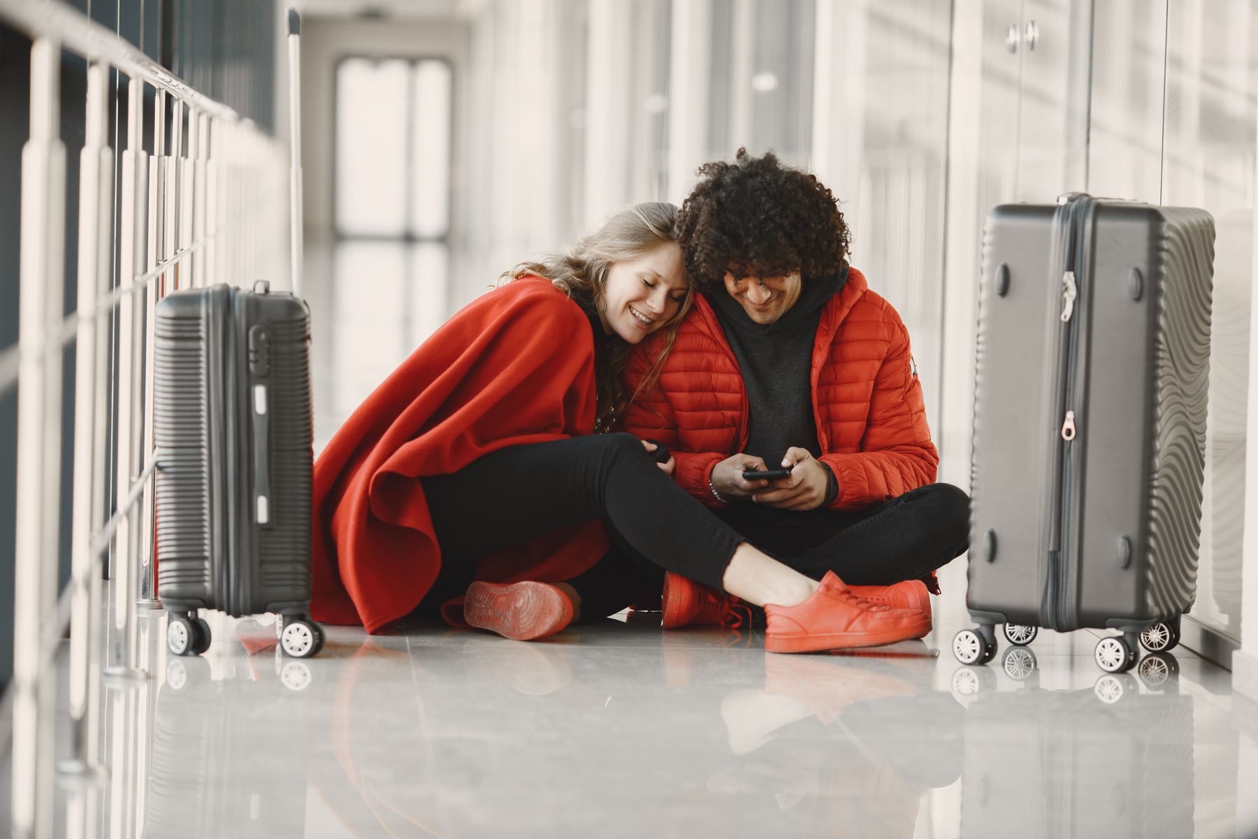 A couple sitting with luggage at the airport