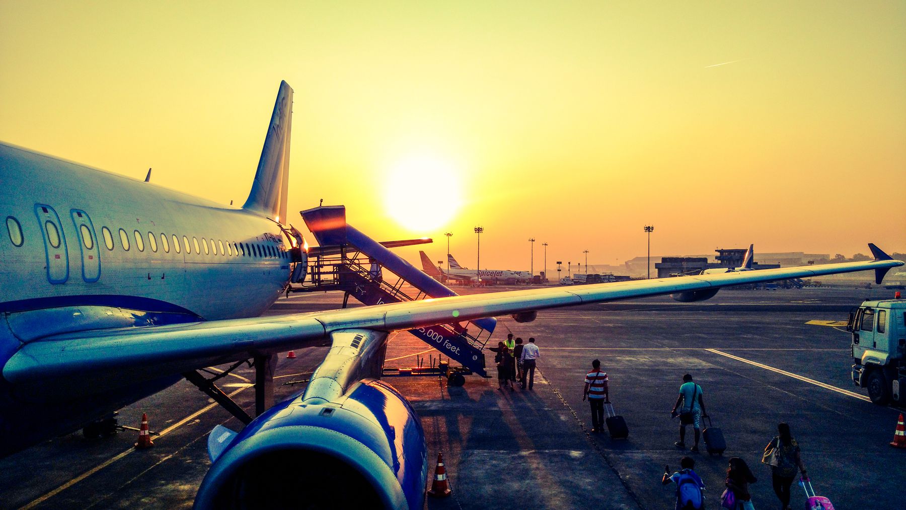Passengers boarding a plane at sunrise