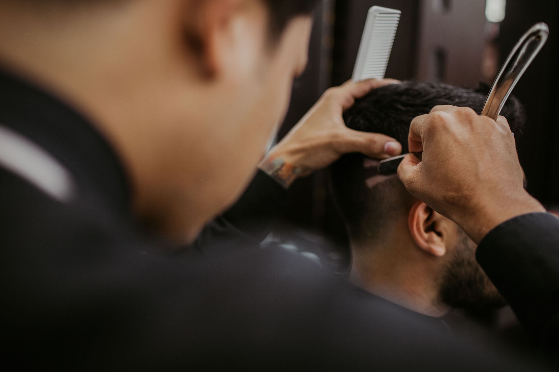 A barber finishing a cut with a razor