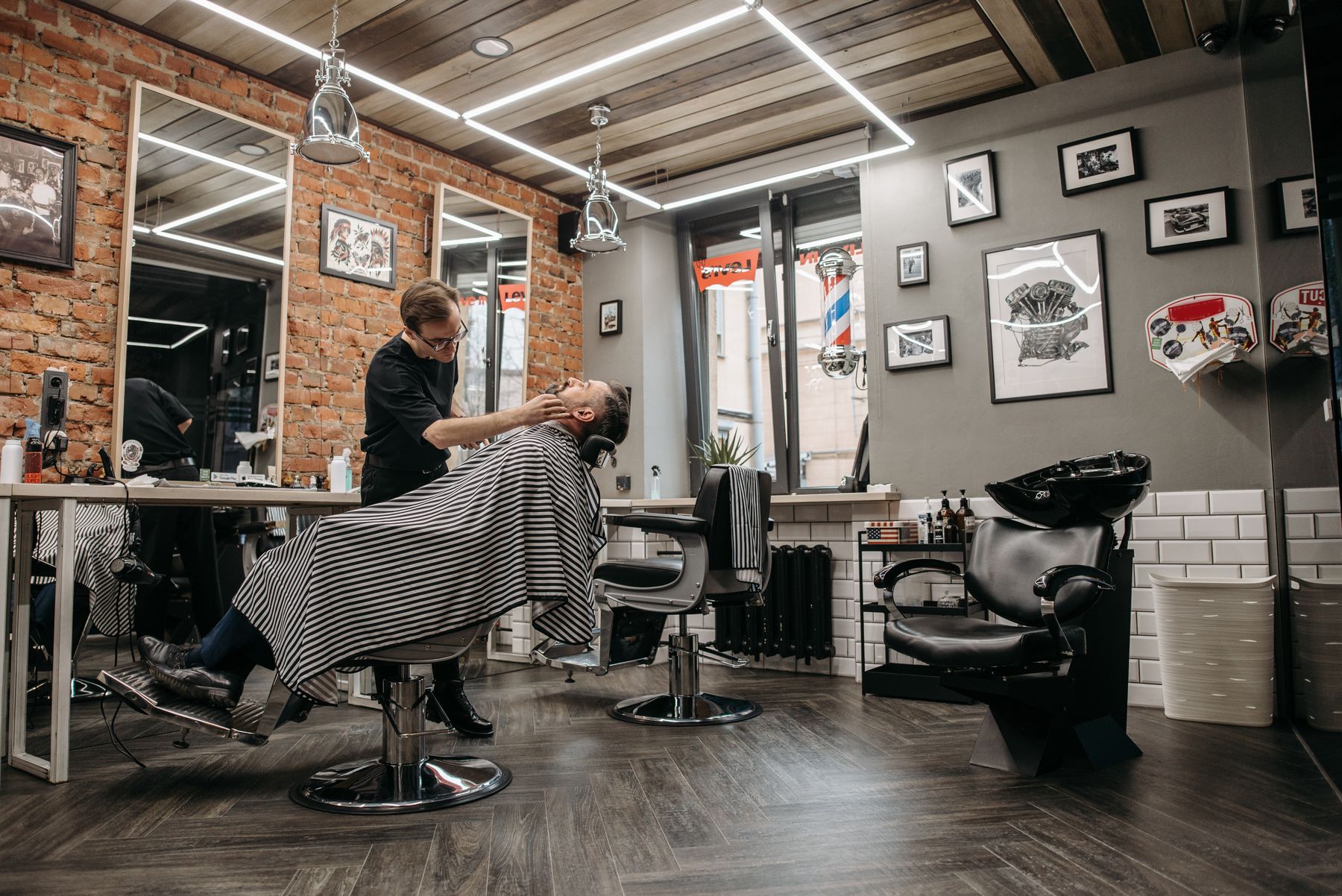 A bright barbershop with brick walls and chairs