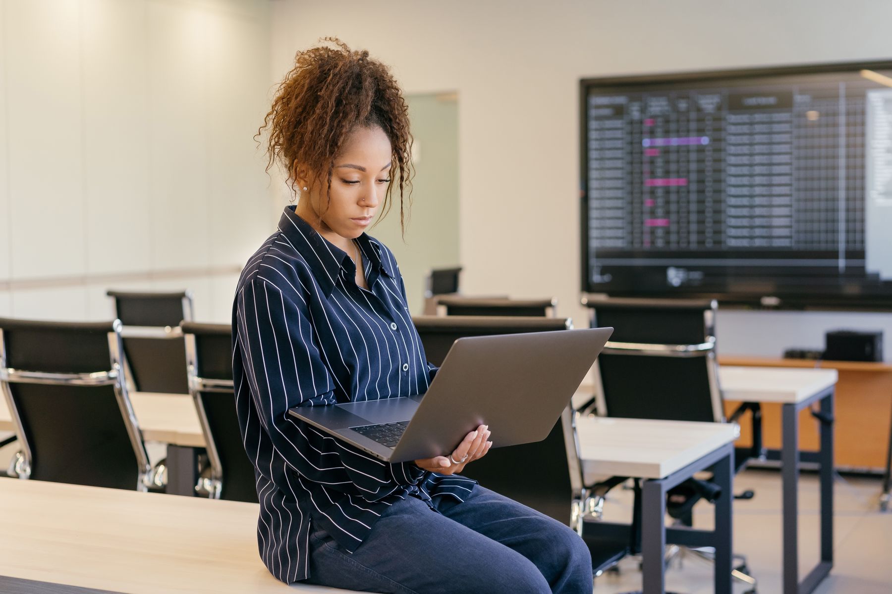 An analyst holding a laptop in an office