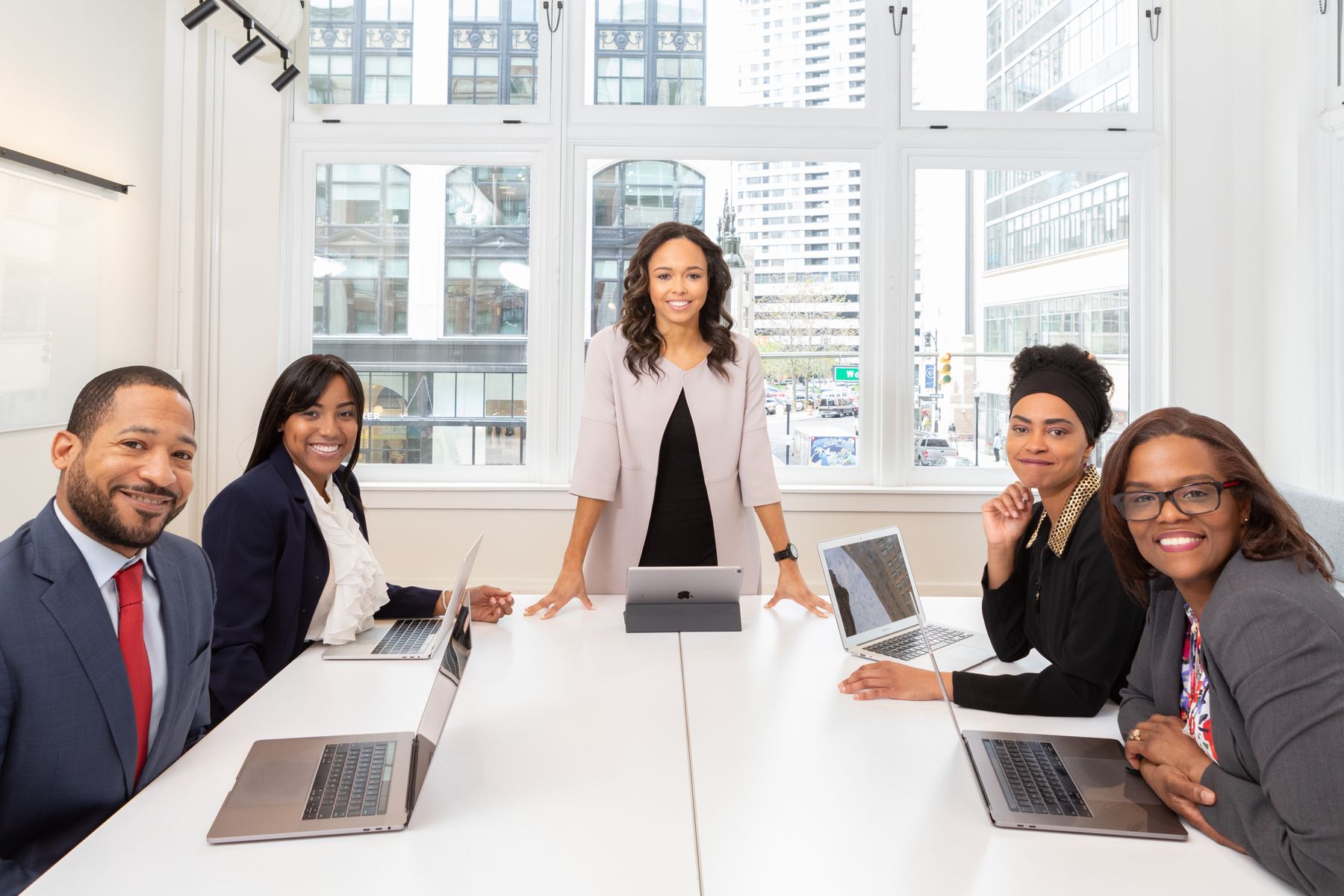 A team meeting around a table with laptops