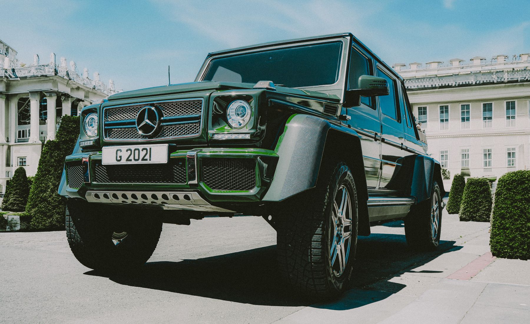 A dark green luxury SUV parked in front of a white building