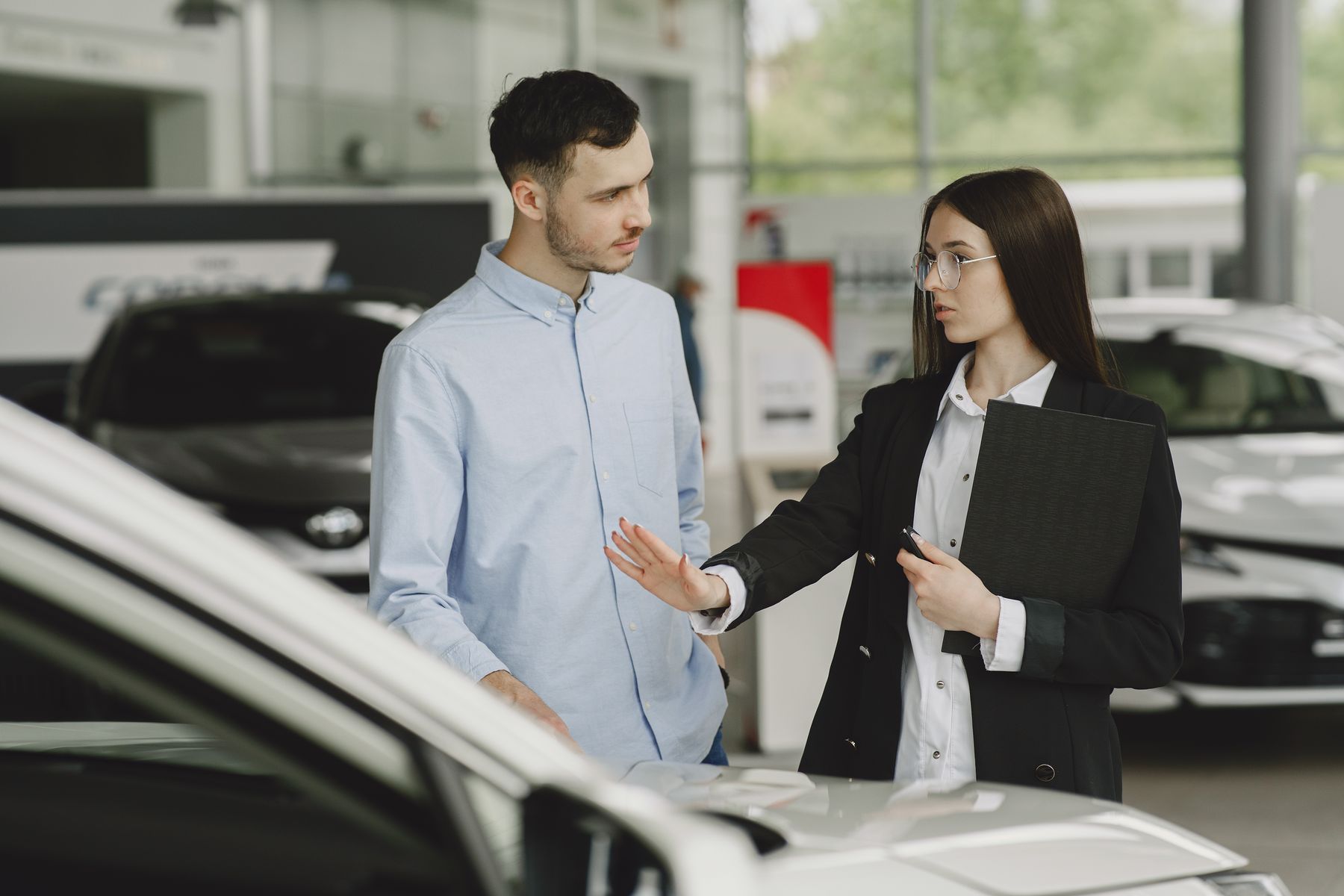 A salesperson and customer discussing a car