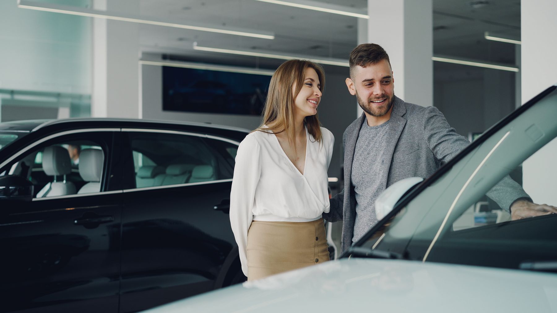 A couple looking at a car in a showroom