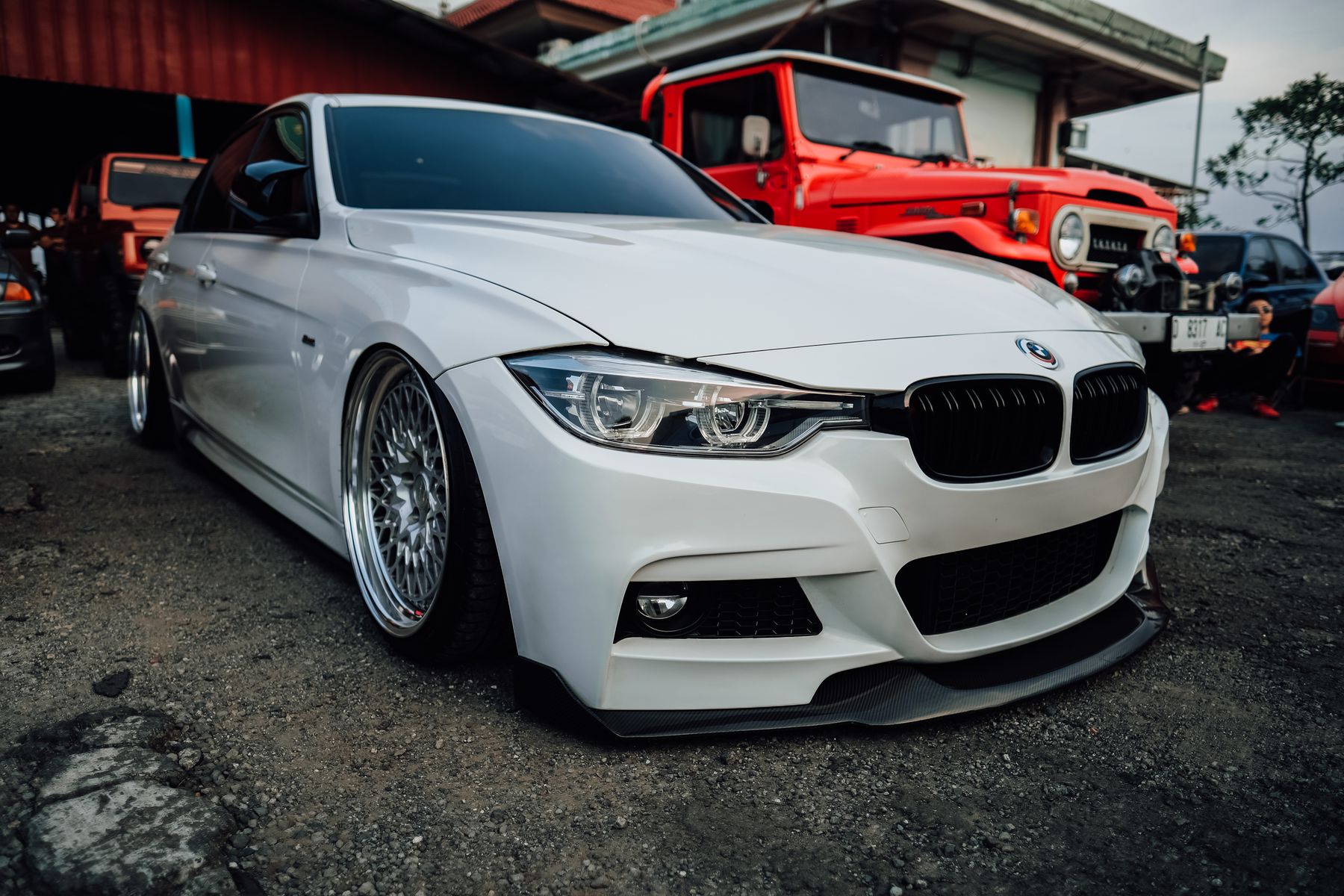 A white sports sedan parked outside a garage