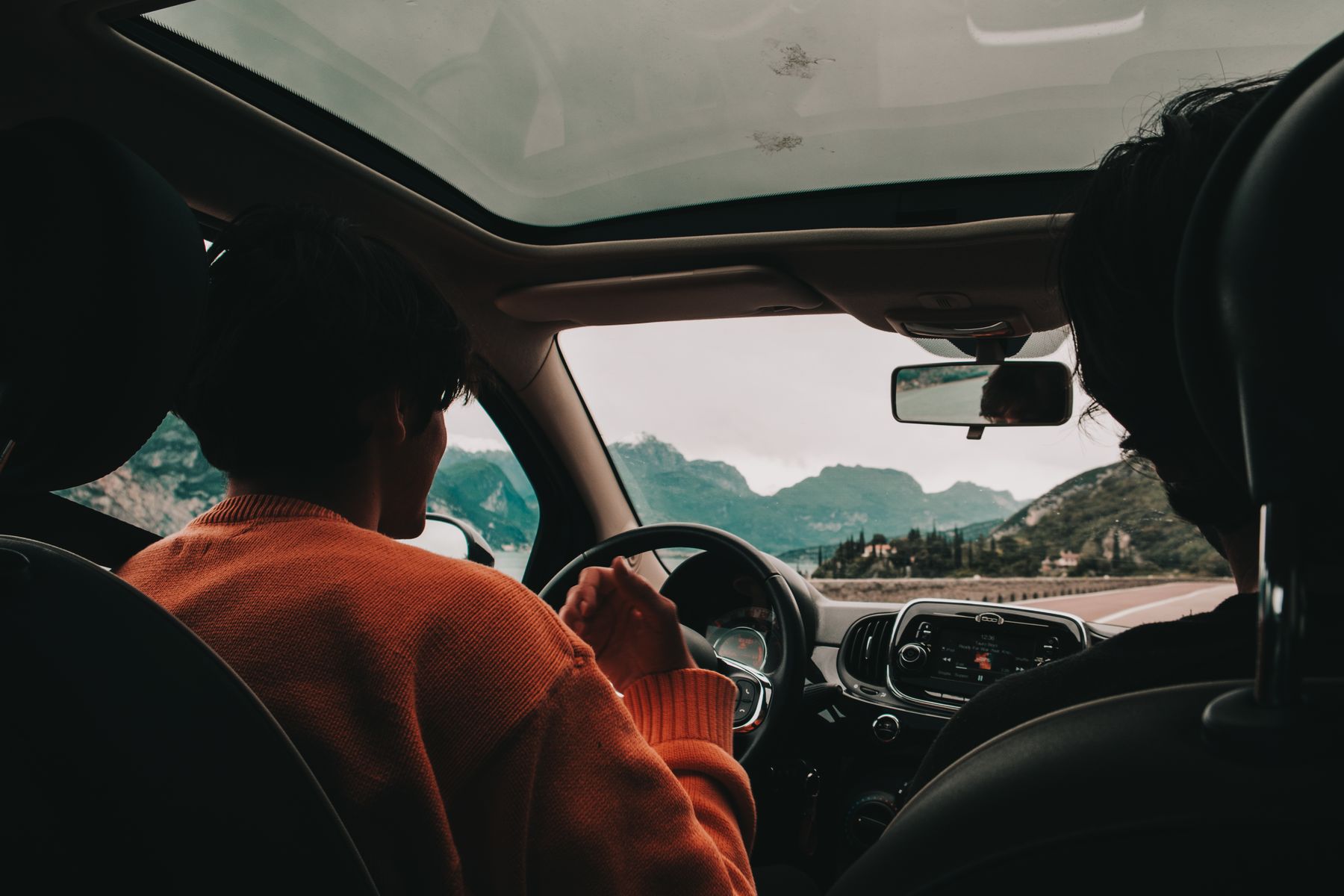 A car driving towards mountains