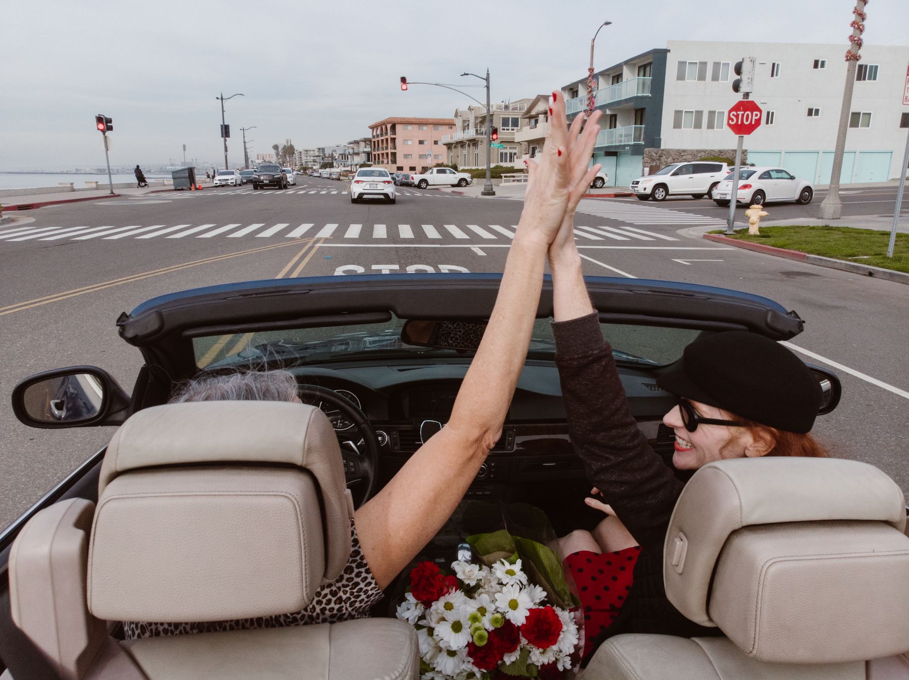 Friends cheering in a convertible