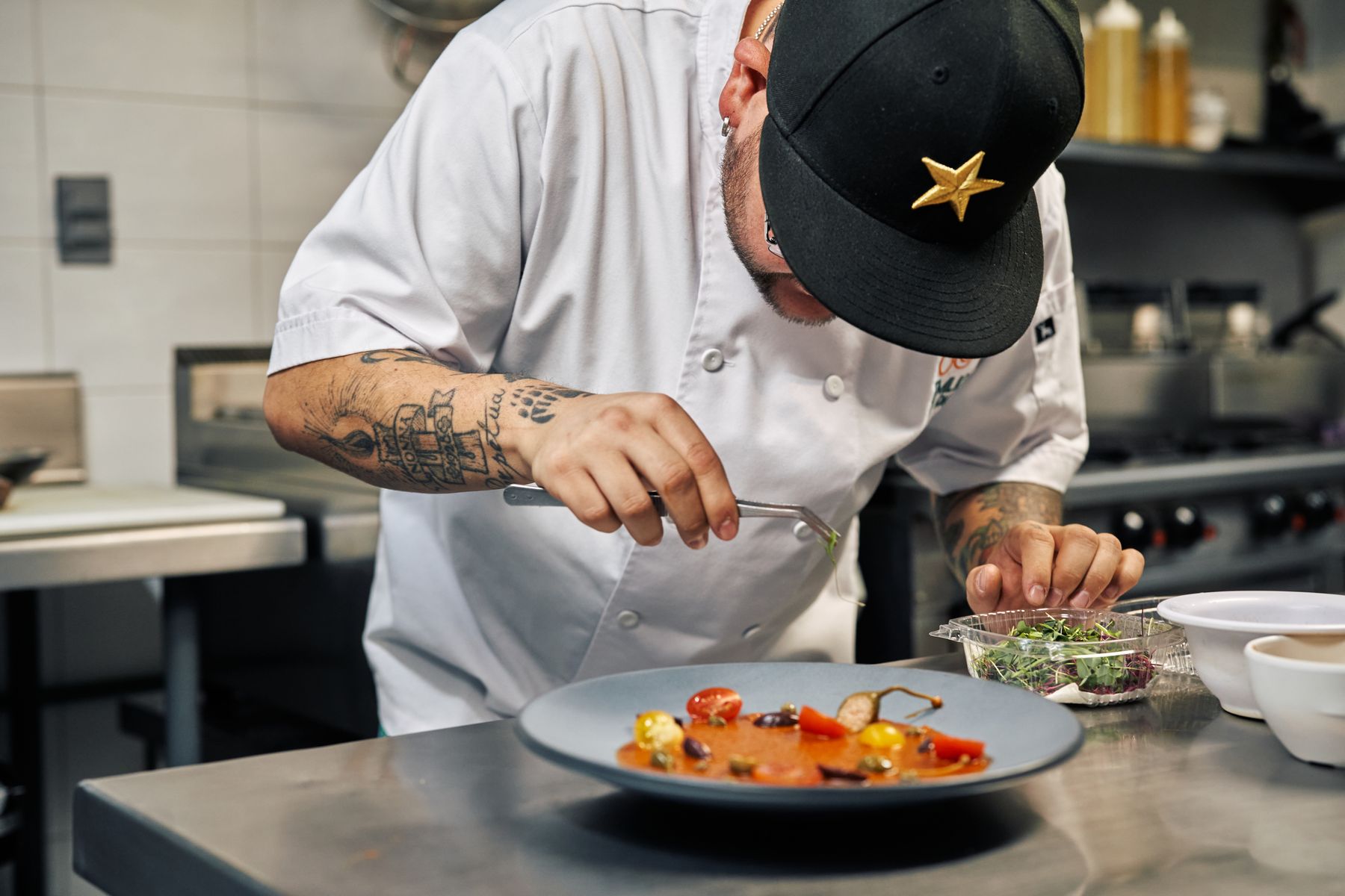 A chef carefully plating a colourful dish
