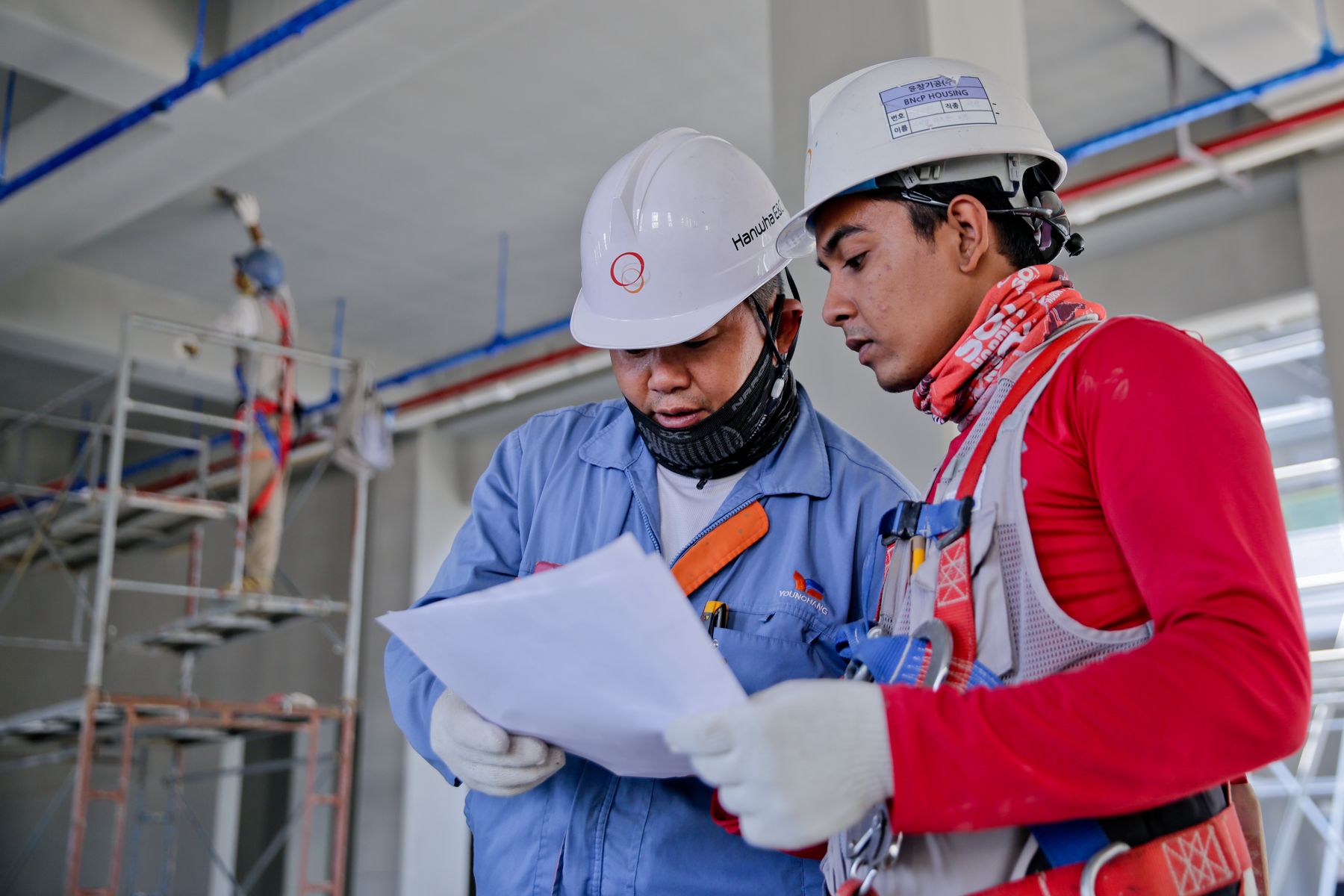 Two engineers reviewing plans on site