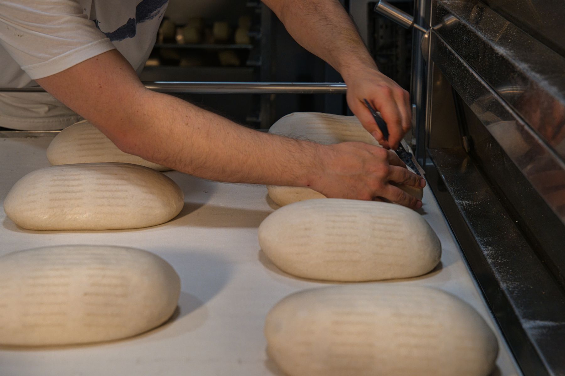 A baker shaping bread loaves