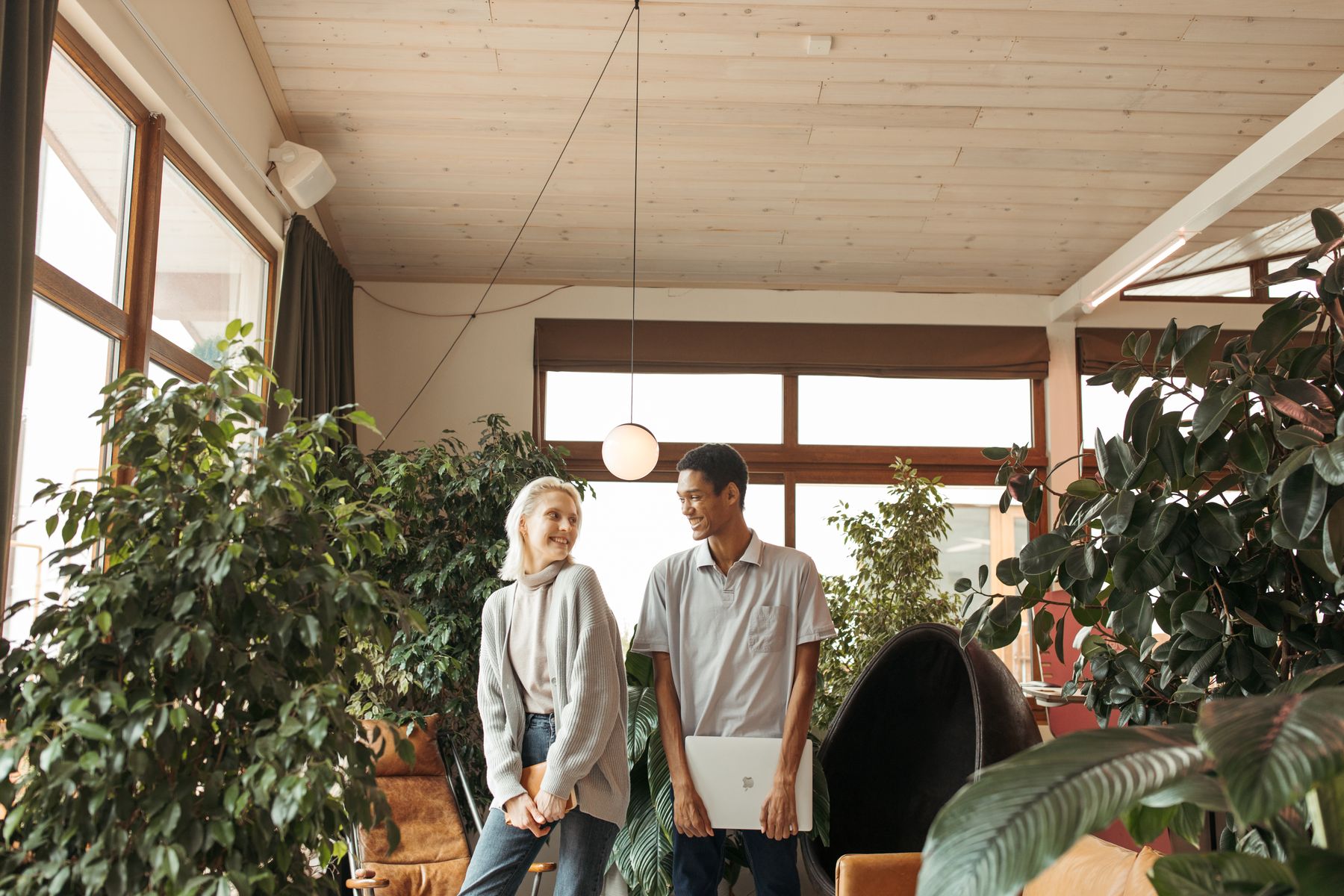 Two colleagues walking through a plant-filled office
