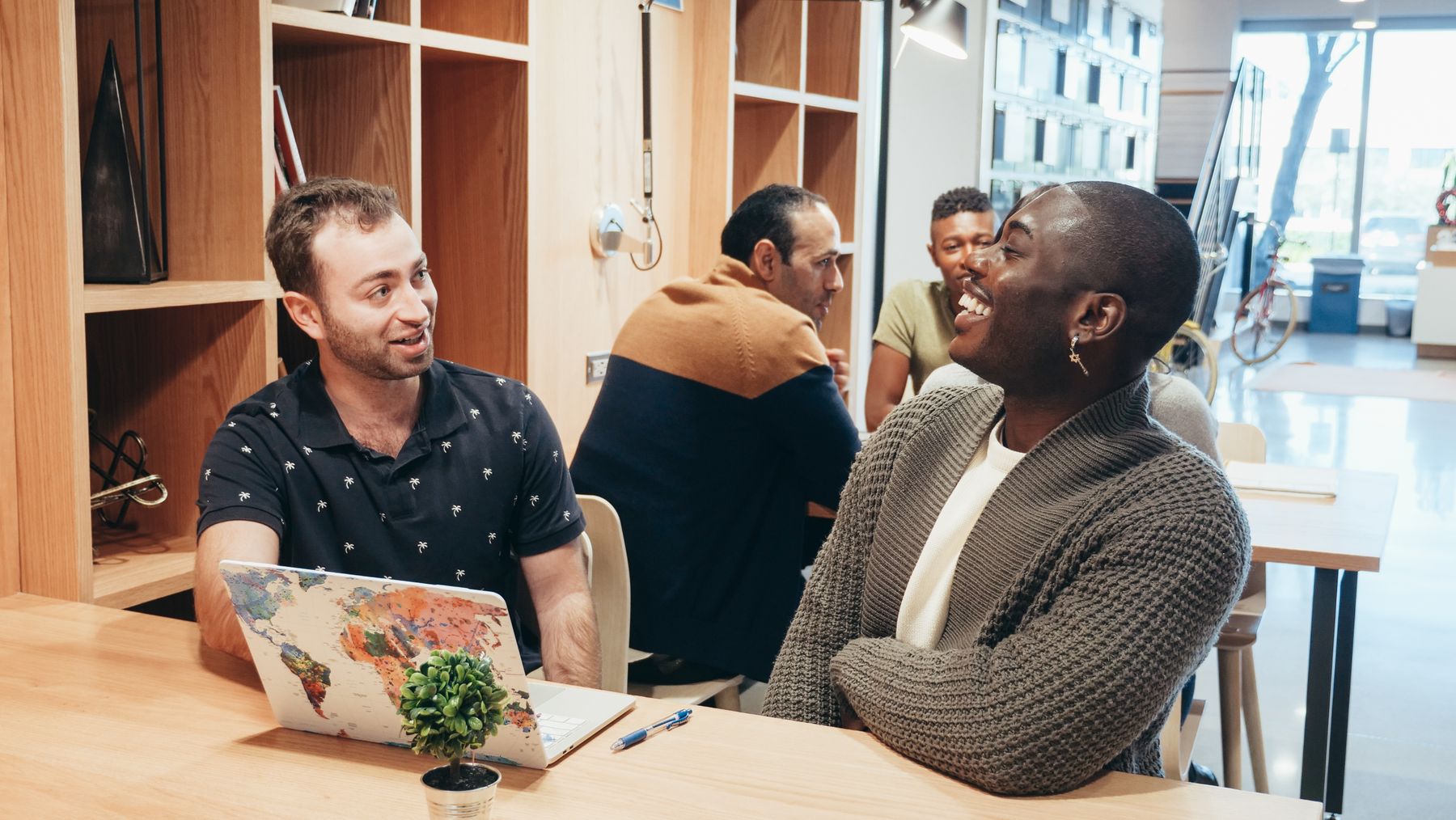 Members chatting around a table with laptops