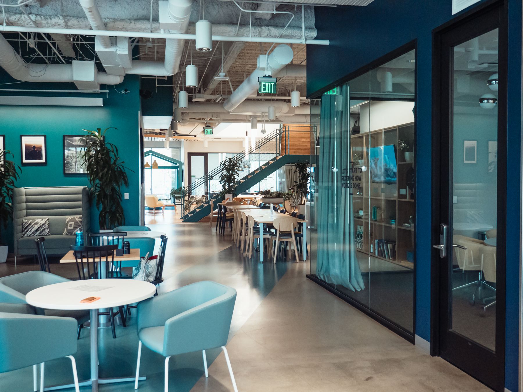 An open lounge with teal chairs