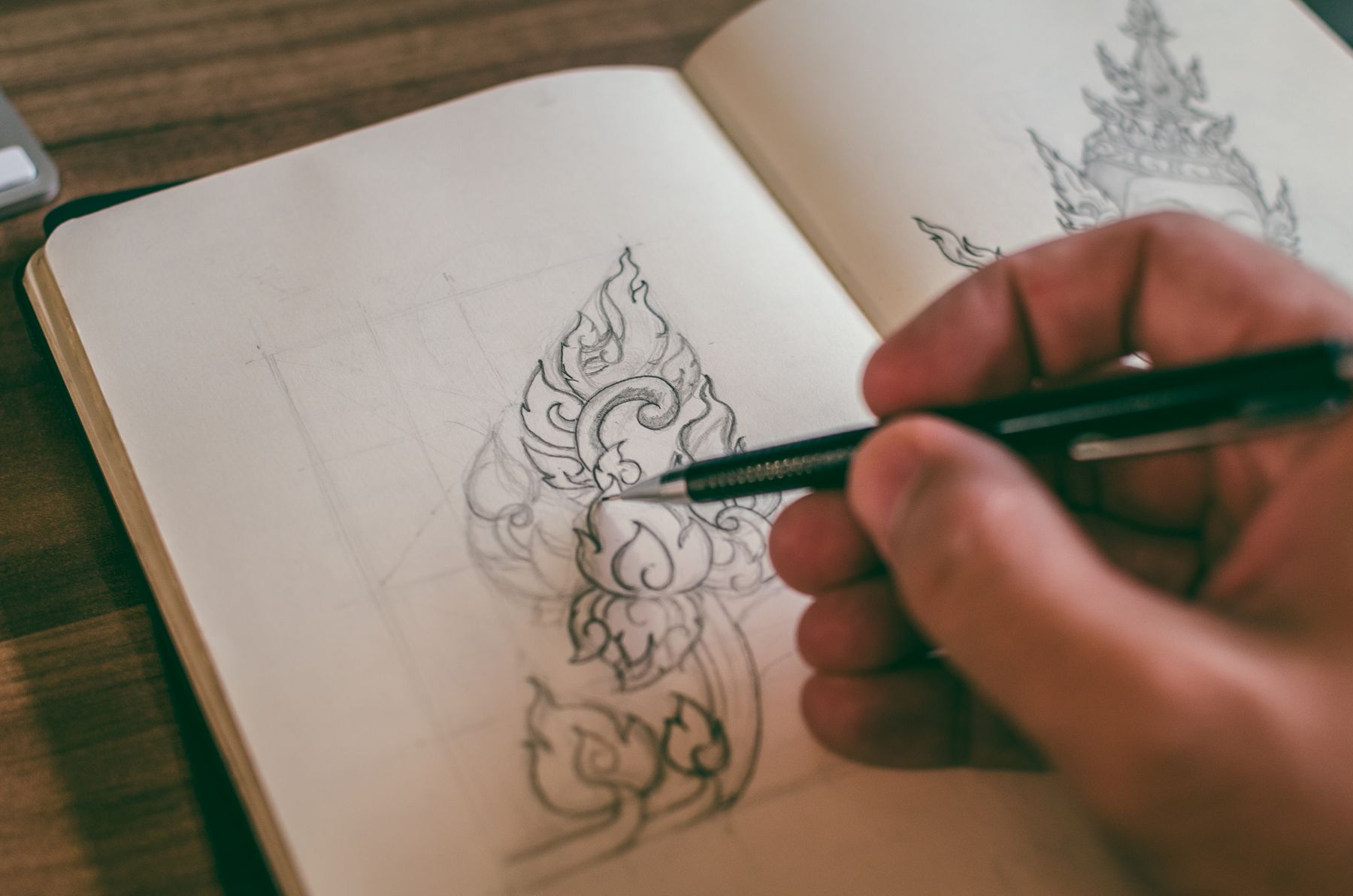 A hand sketching in a notebook