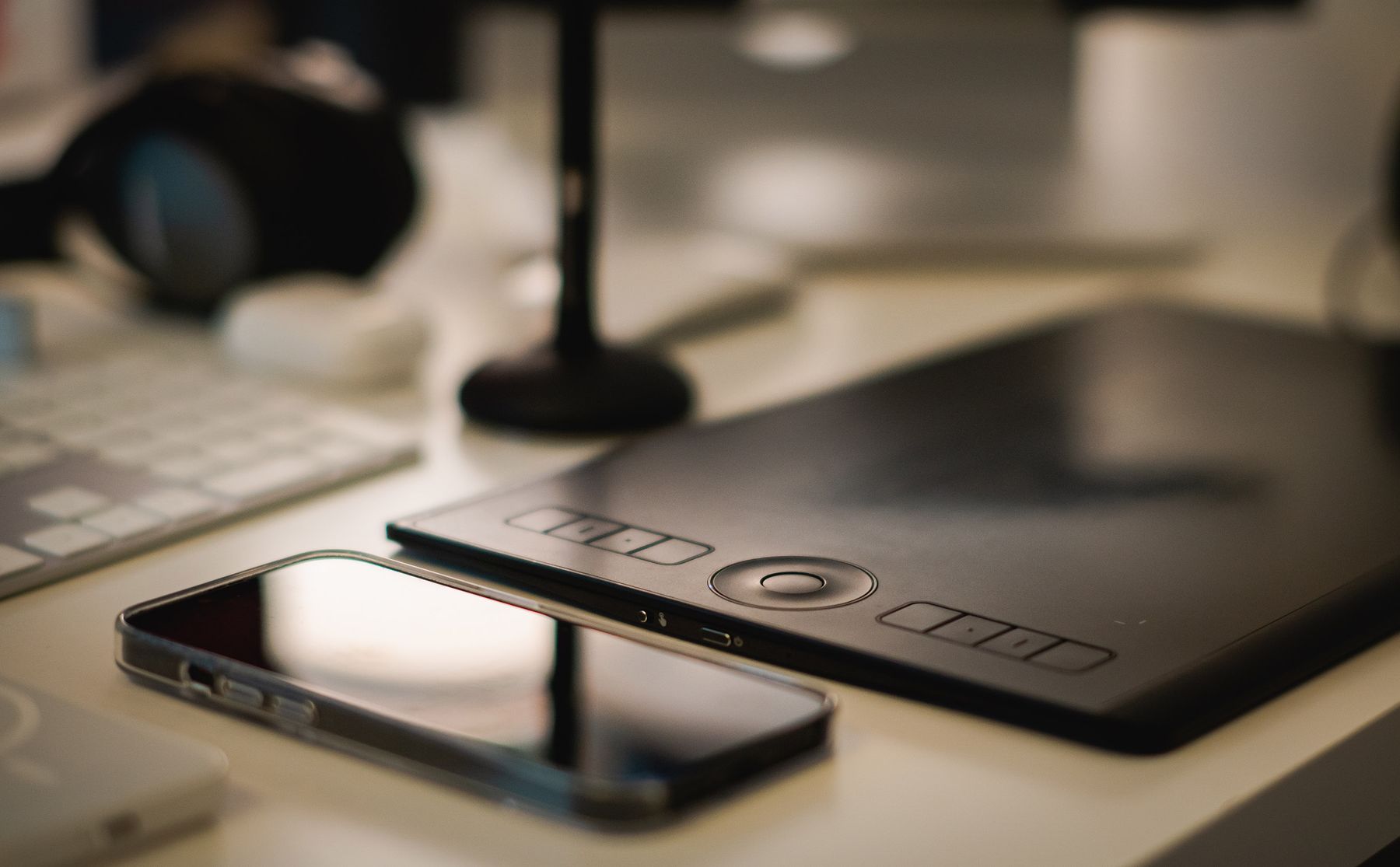 A drawing tablet and phone on a desk