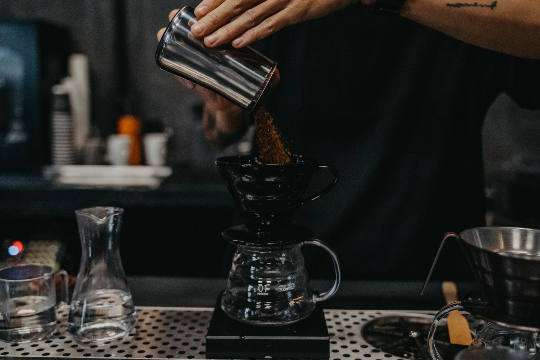 A barista pouring coffee over a filter