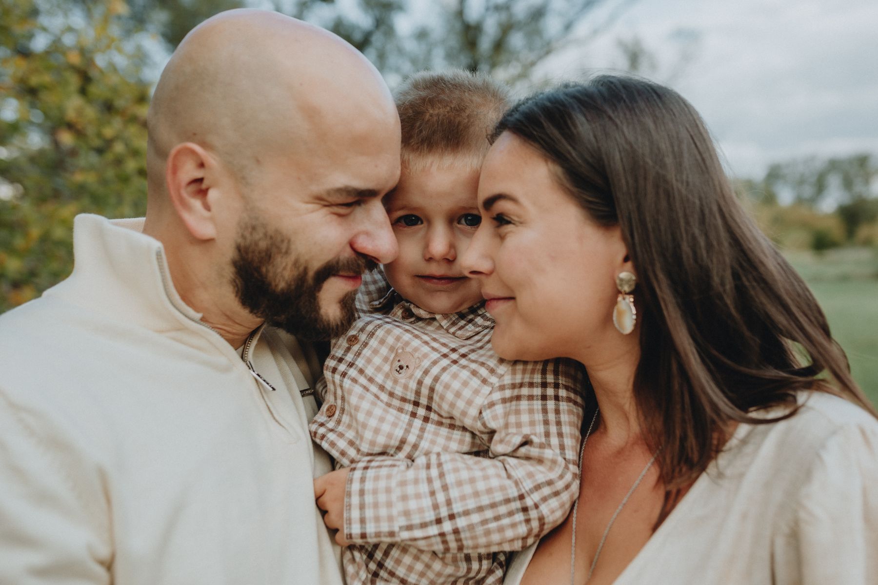 Parents and their child sharing a moment outdoors