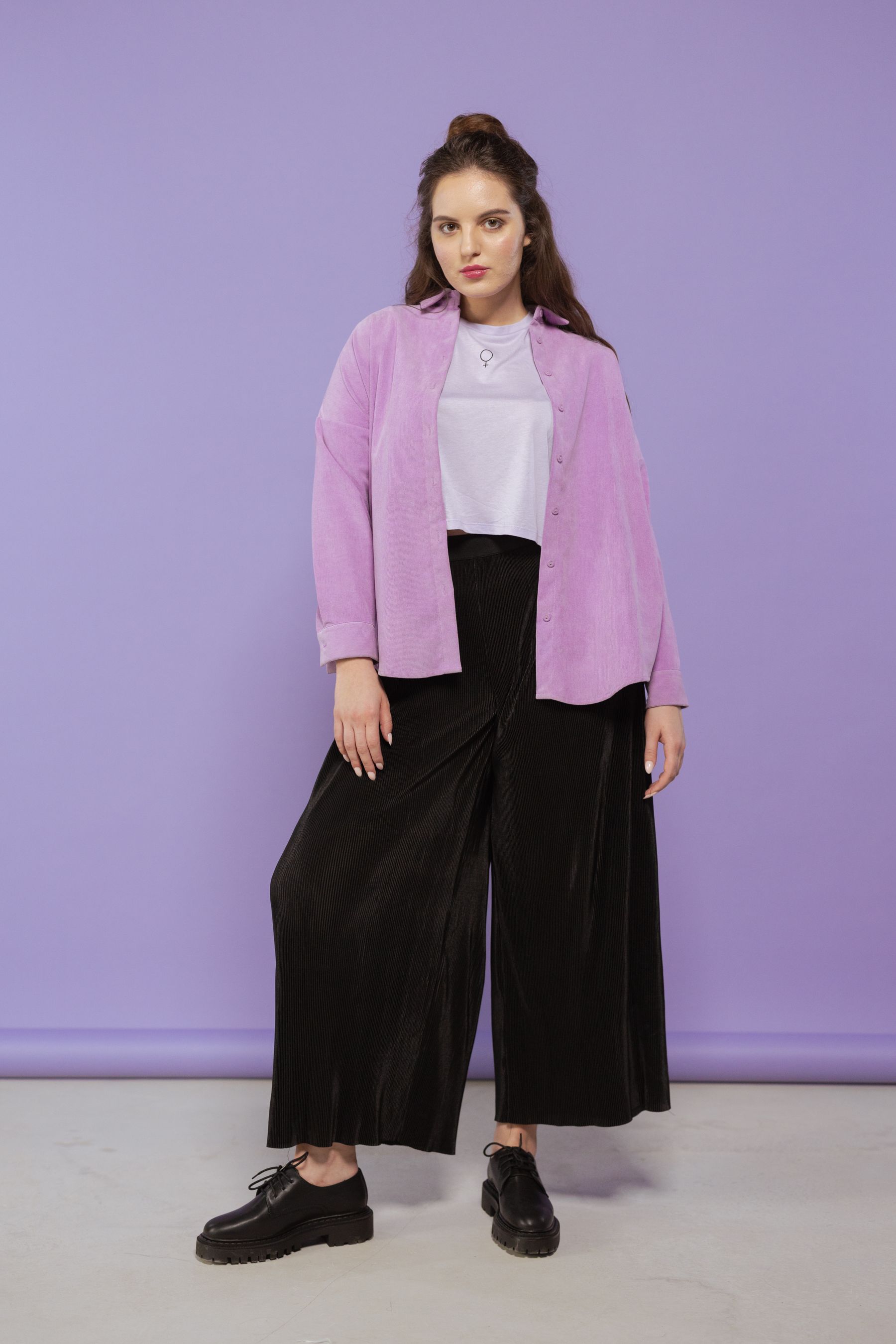 A model in a lilac overshirt against a lavender studio background