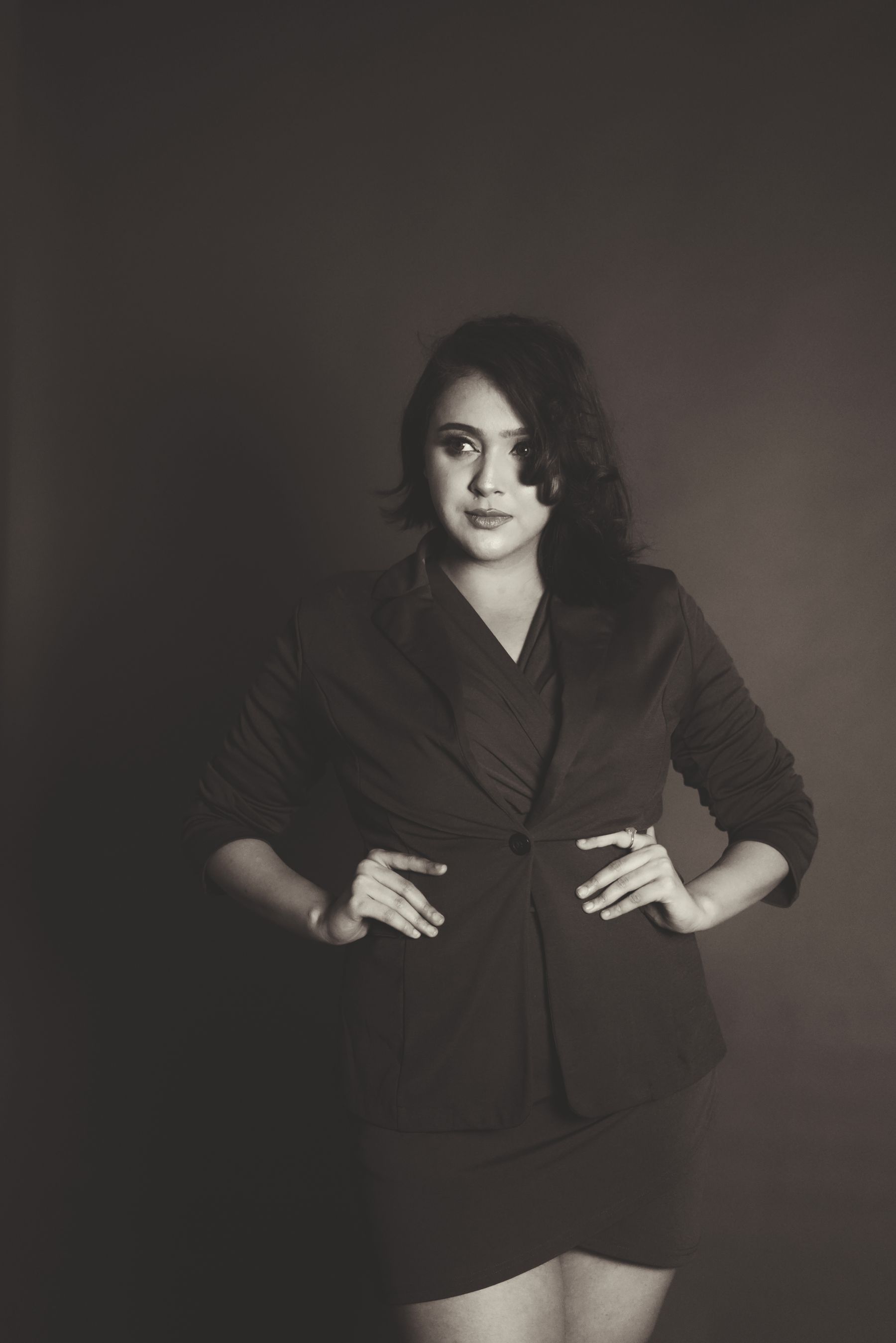 A model wearing a tailored black blazer in a dark studio