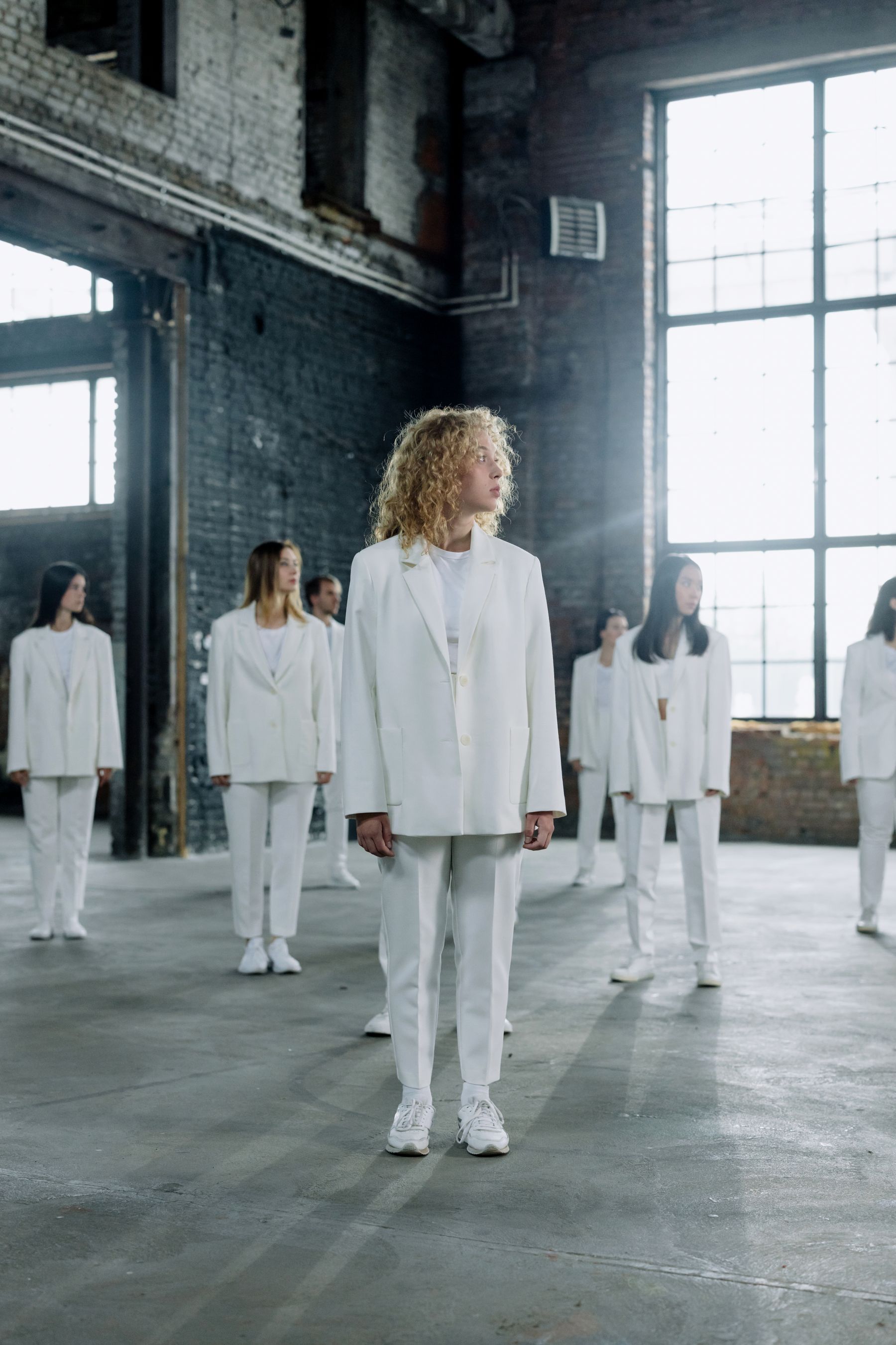 Models wearing white tailoring in a spacious fashion studio